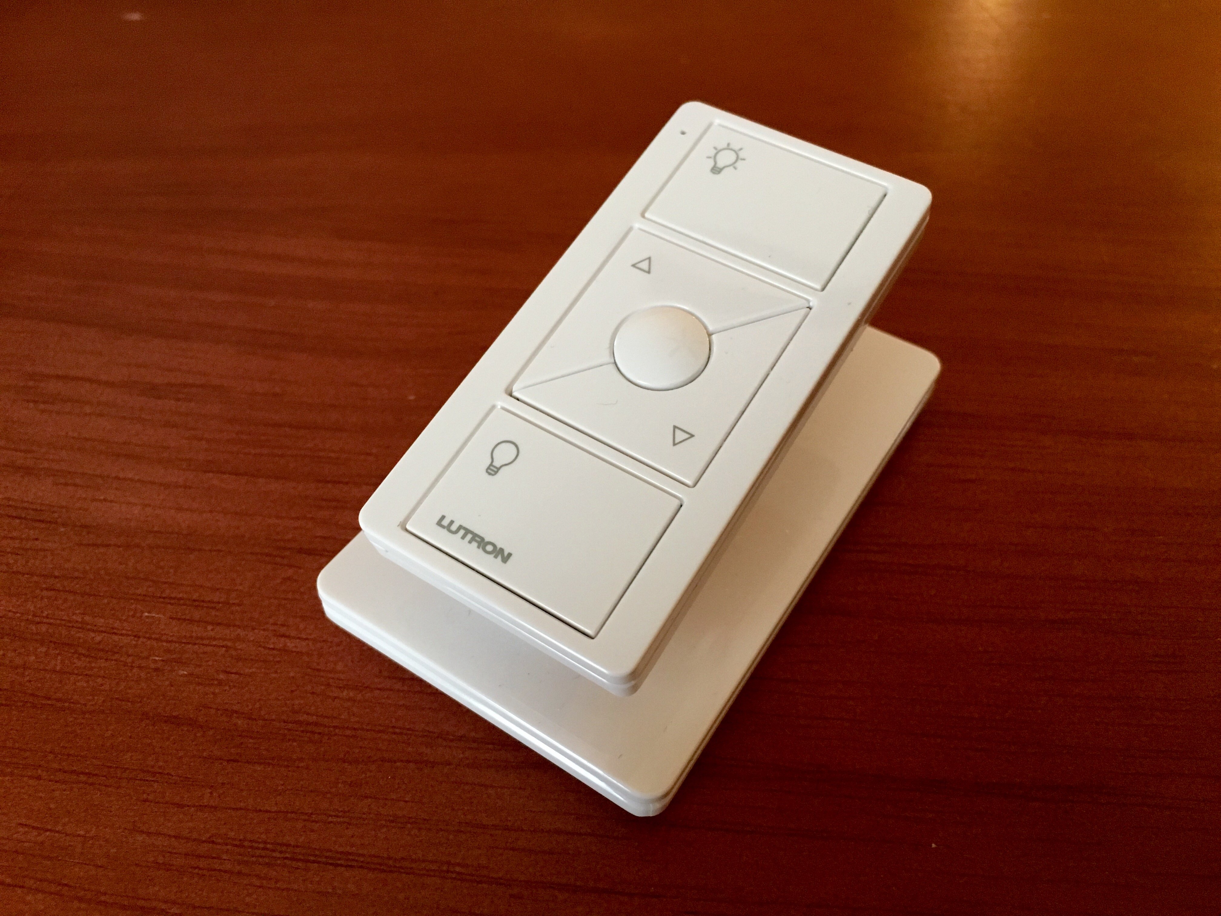 You can wirelessly control your lights with the small Pico remotes, like this one that is on a pedestal.