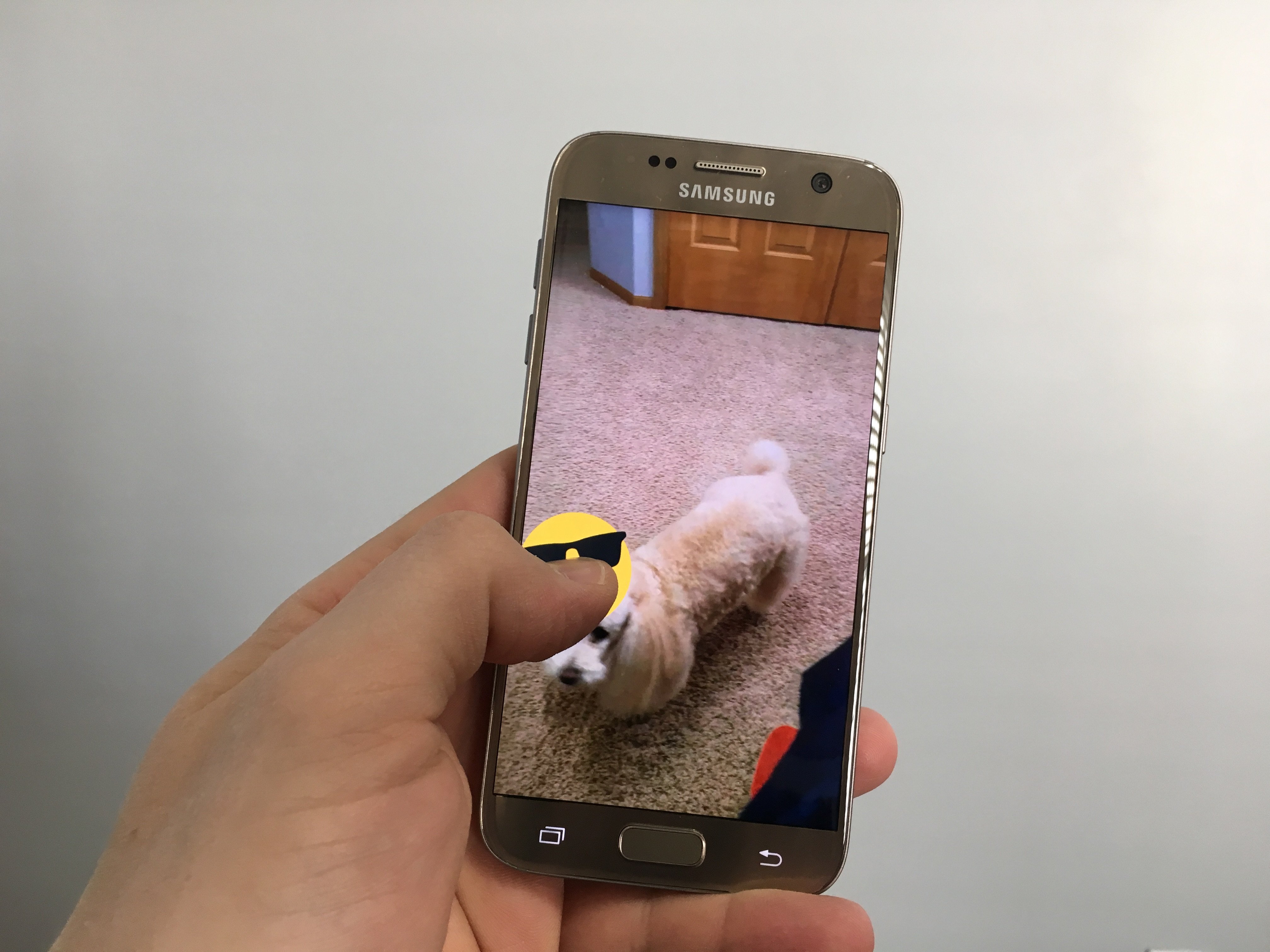 Tap and hold the sticker, the video will stop then you need to place it on an object.